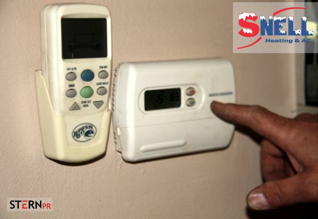 man-sets-thermostat-omaha-hvac-inspections