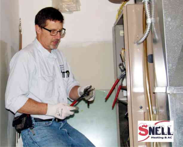 Omaha-furnace-repair-company-owner-jerry-snell-inspects-furnace-for-fall